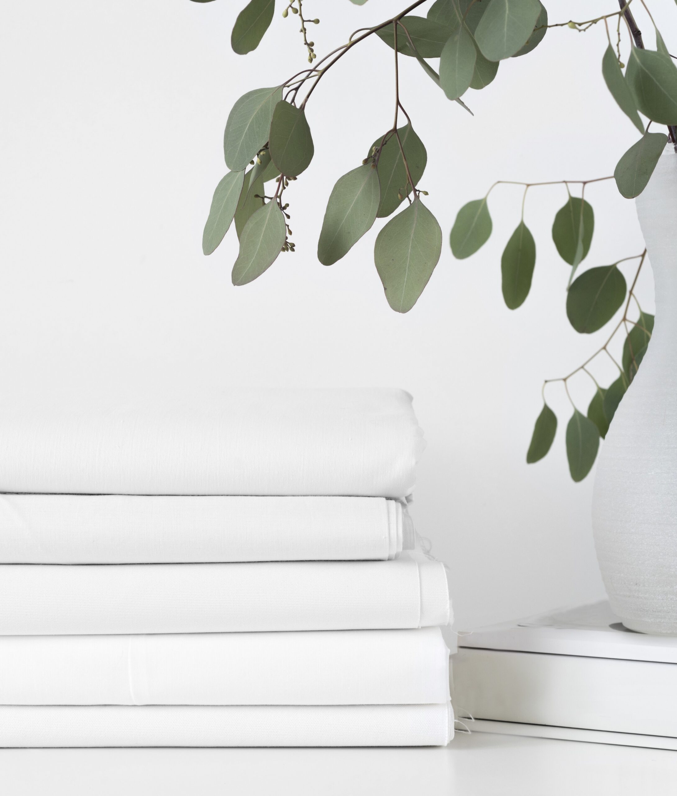 A stack of fabrics over white table background. Mockup. Front view A stack of fabrics over white table background. Mockup. Front view